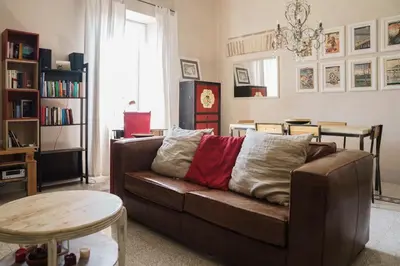 a living room with a brown couch and a table at Casa Mau - Vacation Vibes in Rome