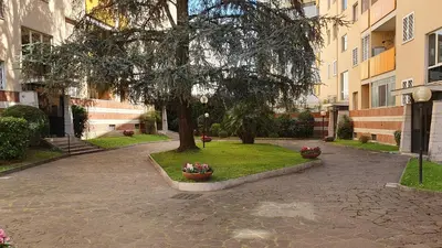 a tree in the middle of a courtyard with flowers at Attico Balduina in Rome