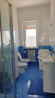 a blue and white bathroom with two toilets and a sink at Attico Balduina in Rome