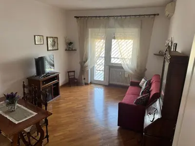 a living room with a red couch and a tv at Attico Balduina in Rome