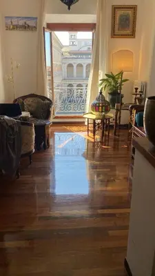 a living room with a wooden floor and a balcony at Obelisco Rhome in Rome