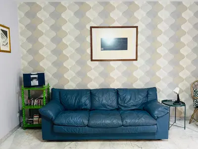 a blue couch in a living room with a picture at La Porta del Perugino - near the Vatican in Rome