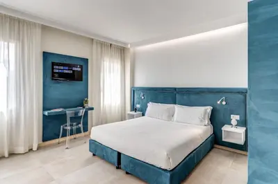 a blue bedroom with a bed and a desk at Boezio 6 Rooms by Roman Dreams in Rome