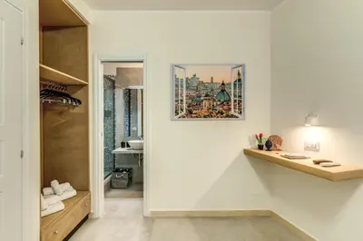 a room with a white wall with a picture on the wall at Boezio 6 Rooms by Roman Dreams in Rome
