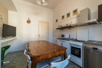 a kitchen with a wooden table and a stove at GuestHost - San Lorenzo Bright Apartment X8 in Rome