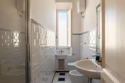 a white bathroom with a sink and a toilet at GuestHost - San Lorenzo Bright Apartment X8 in Rome