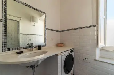 a bathroom with a sink and a washing machine at GuestHost - San Lorenzo Bright Apartment X8 in Rome
