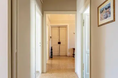 a hallway with white walls and a hallway with a door at GuestHost - San Lorenzo Bright Apartment X8 in Rome