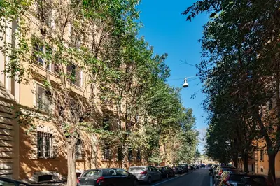 a street with cars parked on the side of a building at GuestHost - San Lorenzo Bright Apartment X8 in Rome