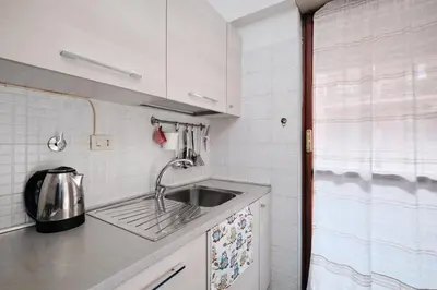 a small kitchen with a sink and white cabinets at Vaticano - Giubileo - A 2 passi da San Pietro by Hôtea in Rome