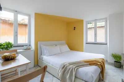 a bedroom with a white bed and two windows at Panieri Apt - Homkeey Apartments in Rome