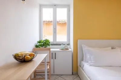 a bedroom with a bed and a table and a window at Panieri Apt - Homkeey Apartments in Rome