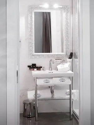 a white bathroom with a sink and a mirror at Piazza di Spagna Suite de Charme in Rome