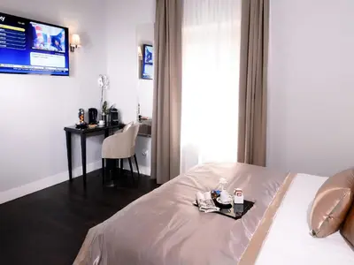 a room with a bed and a table with a television at Piazza di Spagna Suite de Charme in Rome