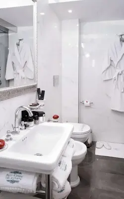 a white bathroom with a sink and a toilet at Piazza di Spagna Suite de Charme in Rome