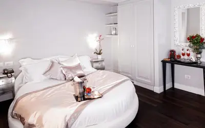 a white bedroom with a white bed with a tray on it at Piazza di Spagna Suite de Charme in Rome