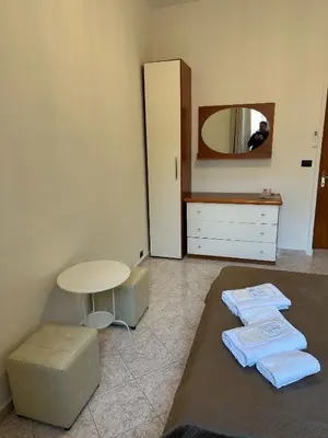 a bedroom with a bed and a table and a mirror at Alloggio Turistico Eli in Rome