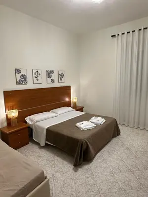 a bedroom with a large bed with a wooden headboard at Alloggio Turistico Eli in Rome
