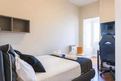 a bedroom with a bed and a flat screen tv at VIVILO COLLECTION - Magna Grecia 29 View Apartment in Rome