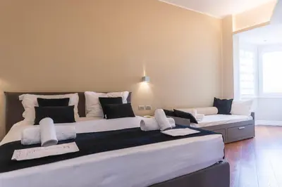 a bedroom with two beds with white and black pillows at VIVILO COLLECTION - Magna Grecia 29 View Apartment in Rome
