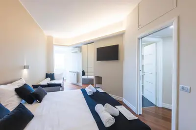 a bedroom with a large bed and a living room at VIVILO COLLECTION - Magna Grecia 29 View Apartment in Rome