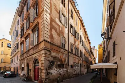 an old brick building on a city street with an umbrella at GuestHost - Apartment Near Piazza Navona in Rome