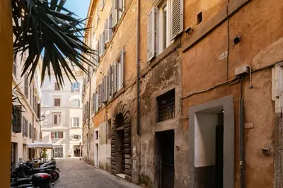 an alley in an old building with motorcycles parked on the street at GuestHost - Apartment Near Piazza Navona in Rome
