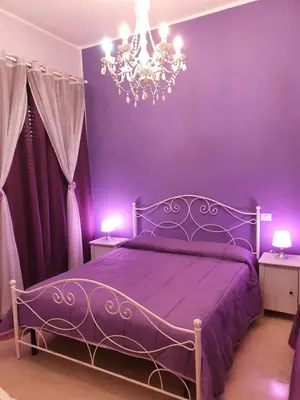 a purple bedroom with a bed and a chandelier at B&B La Casa di Gabry in Rome