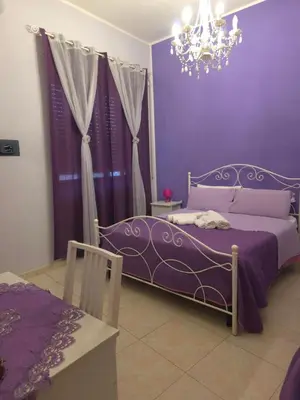 a purple bedroom with a bed and a chandelier at B&B La Casa di Gabry in Rome