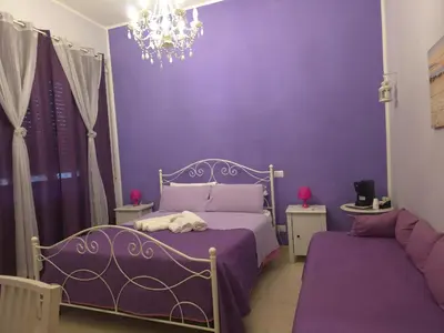 a purple bedroom with a bed and a chandelier at B&B La Casa di Gabry in Rome