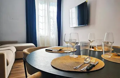 a dining room table with glasses and silverware on it at Gallo 55 Stylish & Modern Stay Near the Vatican in Rome