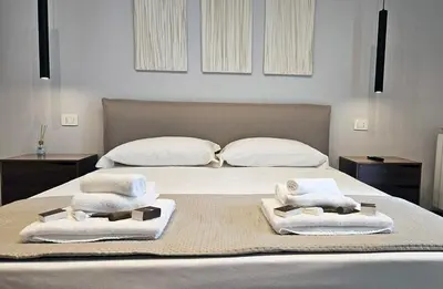 a bedroom with a bed with towels on it at Gallo 55 Stylish & Modern Stay Near the Vatican in Rome