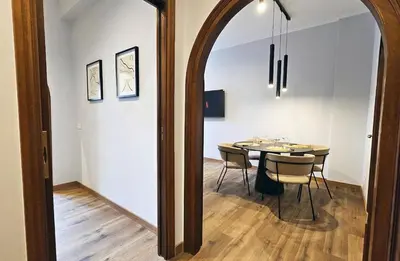 a dining room with a table and chairs and a mirror at Gallo 55 Stylish & Modern Stay Near the Vatican in Rome