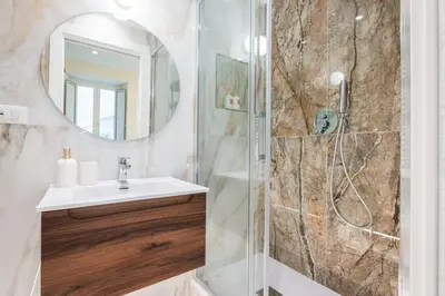 a bathroom with a shower with a sink and a mirror at IV Leoni in Rome