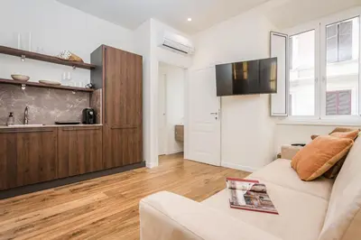a living room with a couch and a kitchen at IV Leoni in Rome