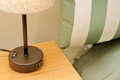 a black lamp sitting on a table next to a bed at Gioia's Flat in Rome