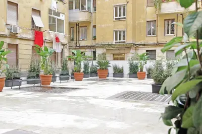 a courtyard with potted plants in front of buildings at Gioia's Flat in Rome