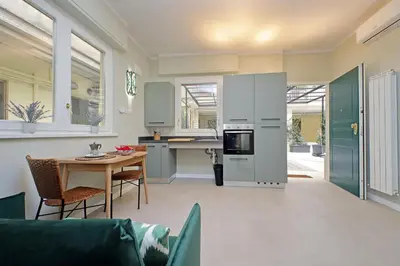 a living room with a table and a kitchen at Gioia's Flat in Rome