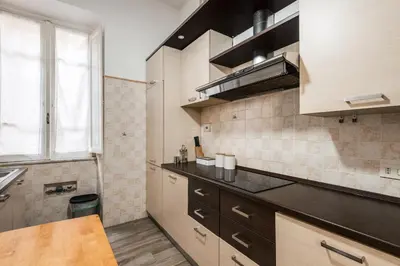 a kitchen with a black counter top and a window at iFlat Mid-Century Modern Vatican Apartment in Rome