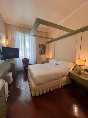 a bedroom with a large bed and a flat screen tv at Residenza Lucullo in Rome