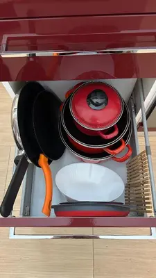 a shelf with plates and utensils in a drawer at Betterplace 2 in Rome