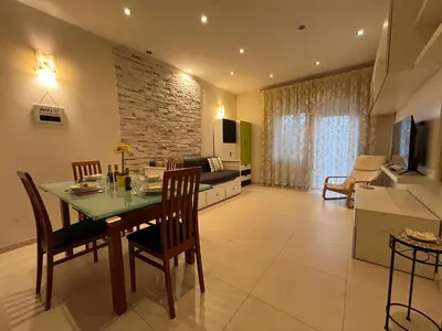 a living room with a table and chairs and a couch at Charm Apartment & Relax Jacuzzi Roma-Gemelli in Rome