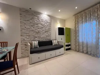 a living room with a couch and a brick wall at Charm Apartment & Relax Jacuzzi Roma-Gemelli in Rome