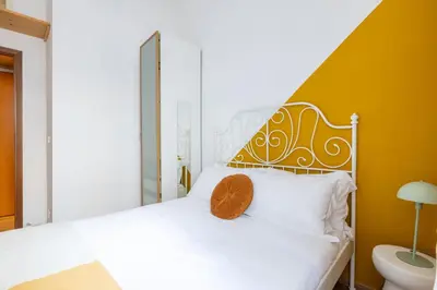 a bedroom with a white bed and a yellow wall at Botanico 24 Apt - Homkeey Apartments in Rome