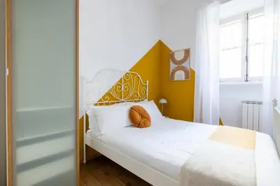 a bedroom with a white bed with a yellow headboard at Botanico 24 Apt - Homkeey Apartments in Rome