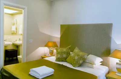 a bedroom with a bed with green and white pillows at Hotel Valeri in Rome