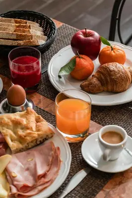a table topped with plates of food and orange juice at Hotel Valeri in Rome