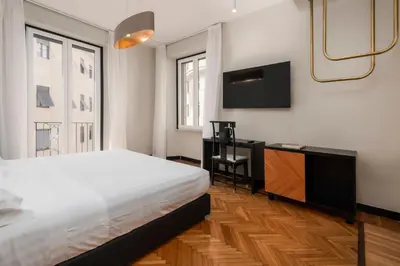 a bedroom with a bed and a television on the wall at Hotel Valeri in Rome