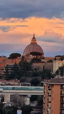 a building with a dome in the distance with a train at Casa Vista San Pietro in Rome
