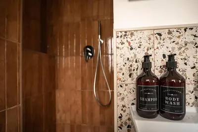 two bottles of wine sitting on the ledge of a shower at Casa Vista San Pietro in Rome